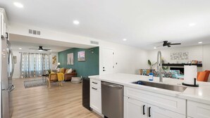 A modern kitchen with white cabinets, a stainless steel dishwasher, and a sink with a modern faucet. - 3bd, Pool, Hot Tub, Garage, Full Kitchen, ASU (Tempe)