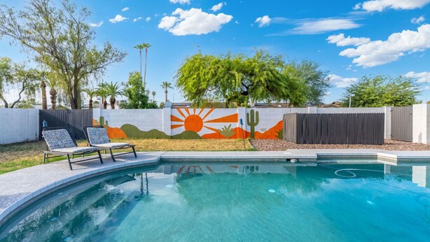 A swimming pool with a mural, a lounge chair, and a cactus decoration. - 3bd, Pool, Hot Tub, Garage, Full Kitchen, ASU (Tempe)