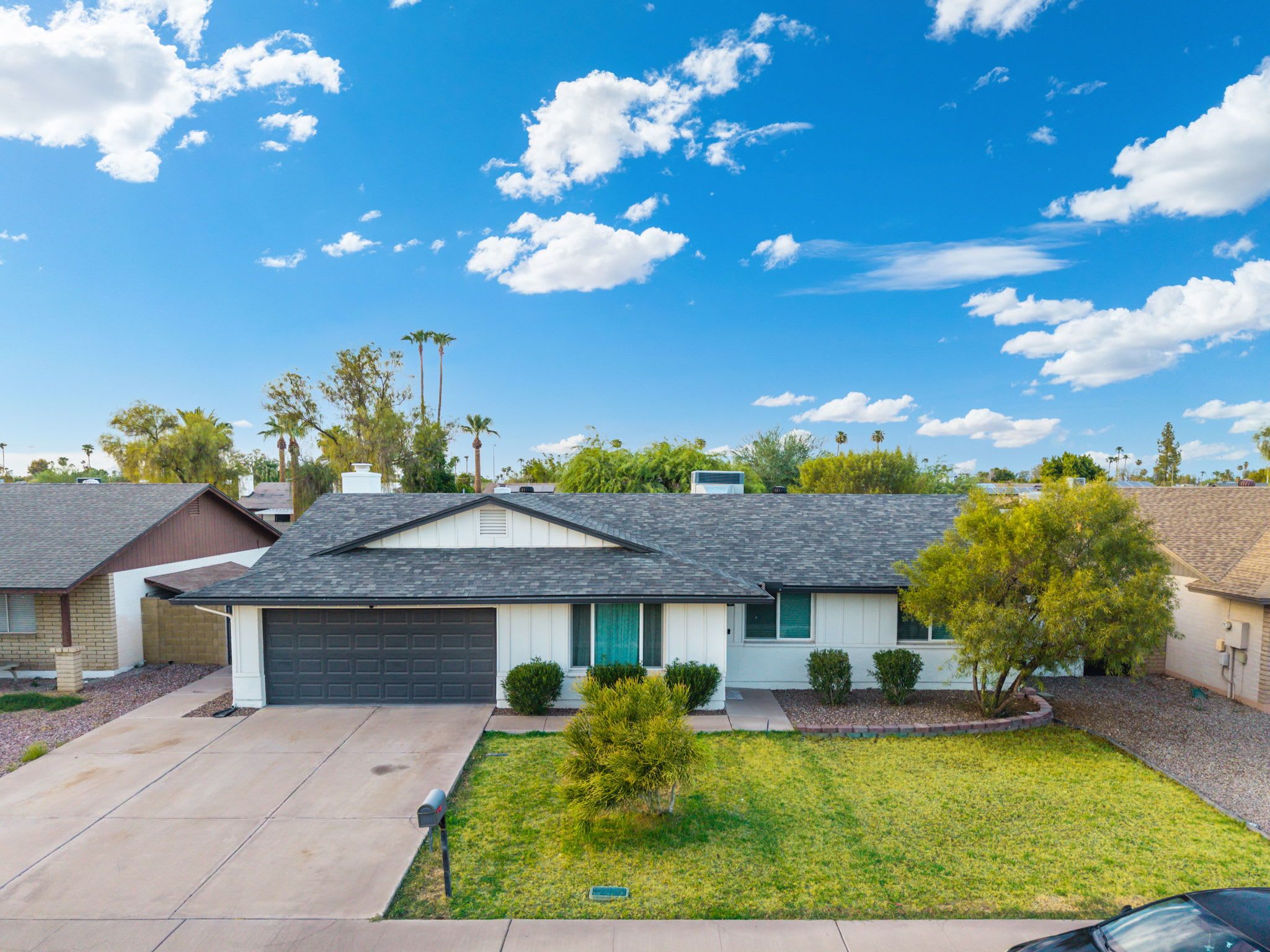 A single-story house with a garage, a front yard, and a clear blue sky.