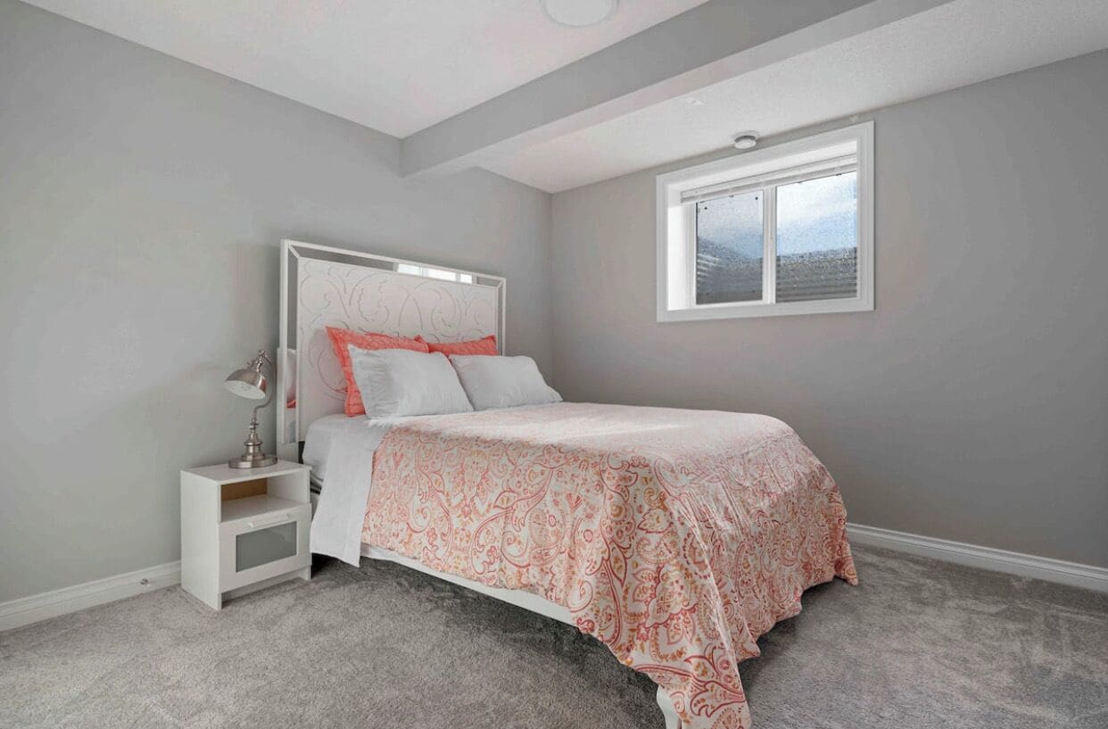 Une chambre à coucher avec un lit, une table de chevet et une fenêtre.