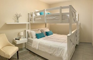 A bunk bed with a white frame, a bedside table with a lamp, and a chair. - Large Central San Salvador Home - Near Downtown, A/C, WiFi, Parking & Netflix (San Salvador Department)