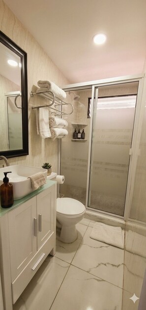 A bathroom with a toilet, sink, and shower area. - Large Central San Salvador Home - Near Downtown, A/C, WiFi, Parking & Netflix (San Salvador Department)