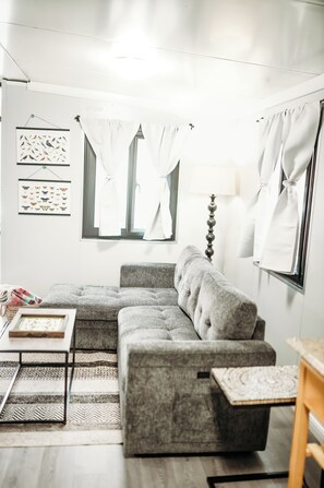 A living room with a sectional sofa, a coffee table, a lamp, and a rug.