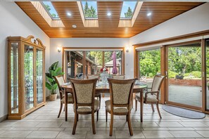 Un comedor con techo de madera, ventanas amplias y vistas al exterior.