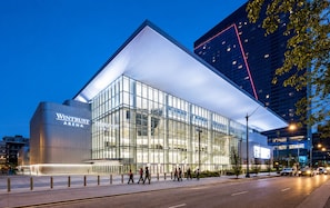 A modern building with a glass facade and a prominent 'Wintrust Arena' sign. - Spacious 3BR Suite with Skyline Views Near McCormick (Chicago)