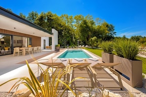 A modern outdoor pool area with lounge chairs and a dining area. - Villa Uno (Istria - Žminj) (Rovinj)