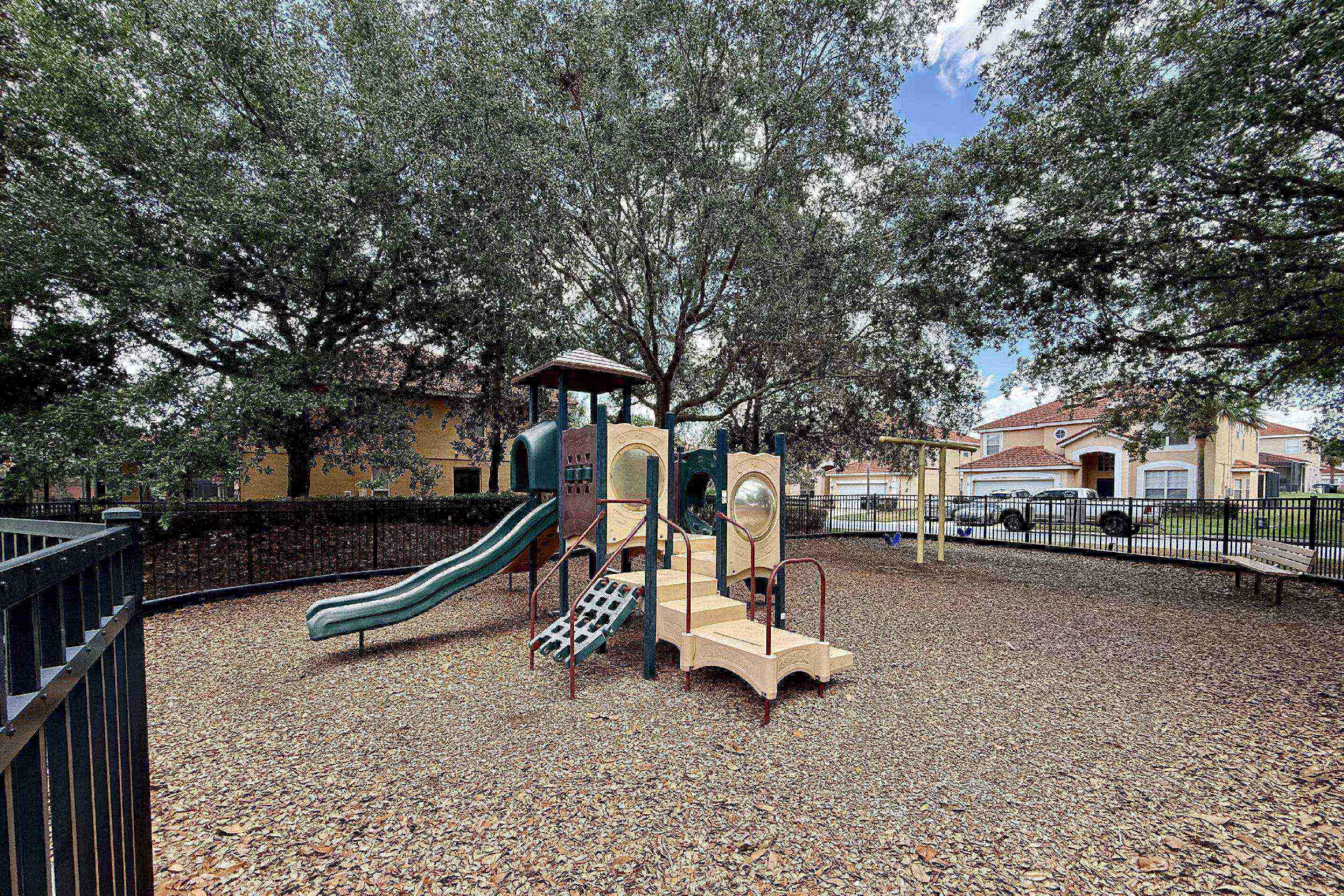 A playground with a slide, climbing area, and a small shelter.