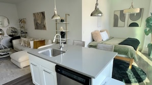 Uma cozinha moderna com lava-louças, pia e área de refeições com mesa e cadeiras.