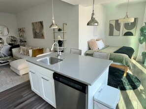Eine moderne Küche mit Geschirrspüler, Spüle und Essbereich mit Tisch und Stühlen.