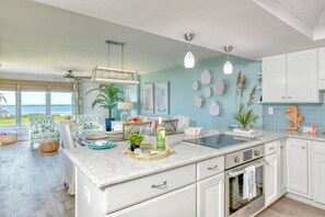 A kitchen with white cabinets, a marble countertop, and a view of the ocean. - Luxurious Oceanfront Condo, Amazing Ocean Sunrise and Intercoastal Sunset Views, Steps to Sand, Pool (St. Augustine)
