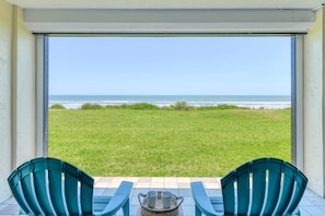 A balcony with two chairs, a small table, and a view of the ocean. - Luxurious Oceanfront Condo, Amazing Ocean Sunrise and Intercoastal Sunset Views, Steps to Sand, Pool (St. Augustine)