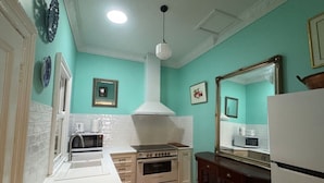 A kitchen with a stove, oven, microwave, and a refrigerator.