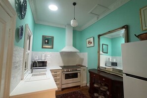 Una cocina equipada con estufa, horno, microondas y refrigerador.