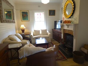 Una sala de estar acogedora con chimenea, un sofá, una mesa de centro y una televisión.