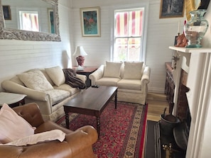 A living room with two sofas, a coffee table, a fireplace, and a rug.