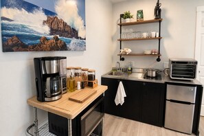 Una cuina moderna amb cafetera, envasos, torradora i un rentaplat.