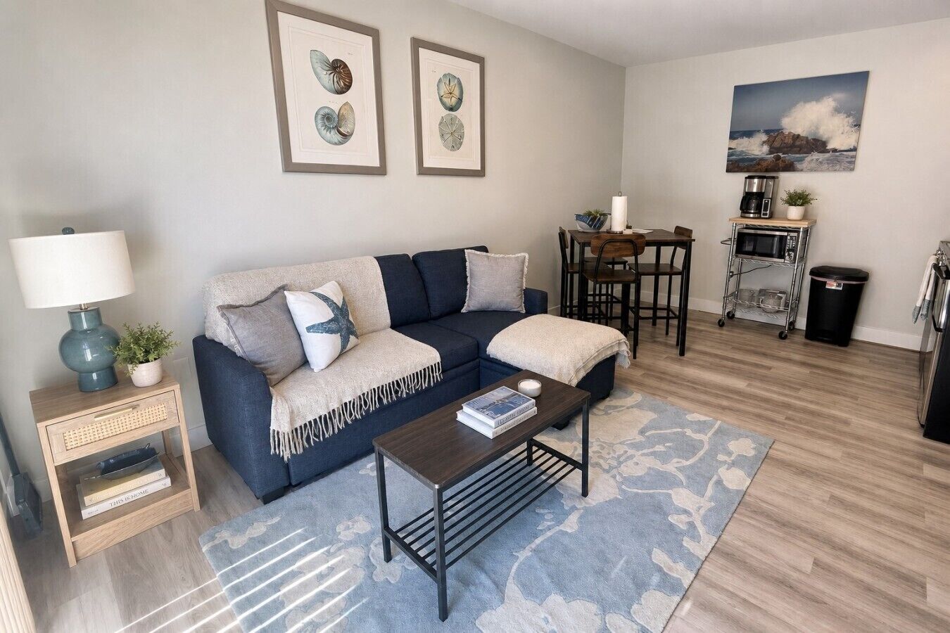 A living room with a sofa, coffee table, and a dining area with a table and chairs.