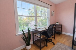 A room with a large window, a desk with a chair, a small plant, and a picture on the wall. - Sleep up to 12, quick access to Kittery and Portsmouth, Beaches, Boat Launch (Eliot)