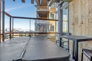 Ein Balkon mit Blick auf andere Gebäude, einem Tisch und Stühlen.