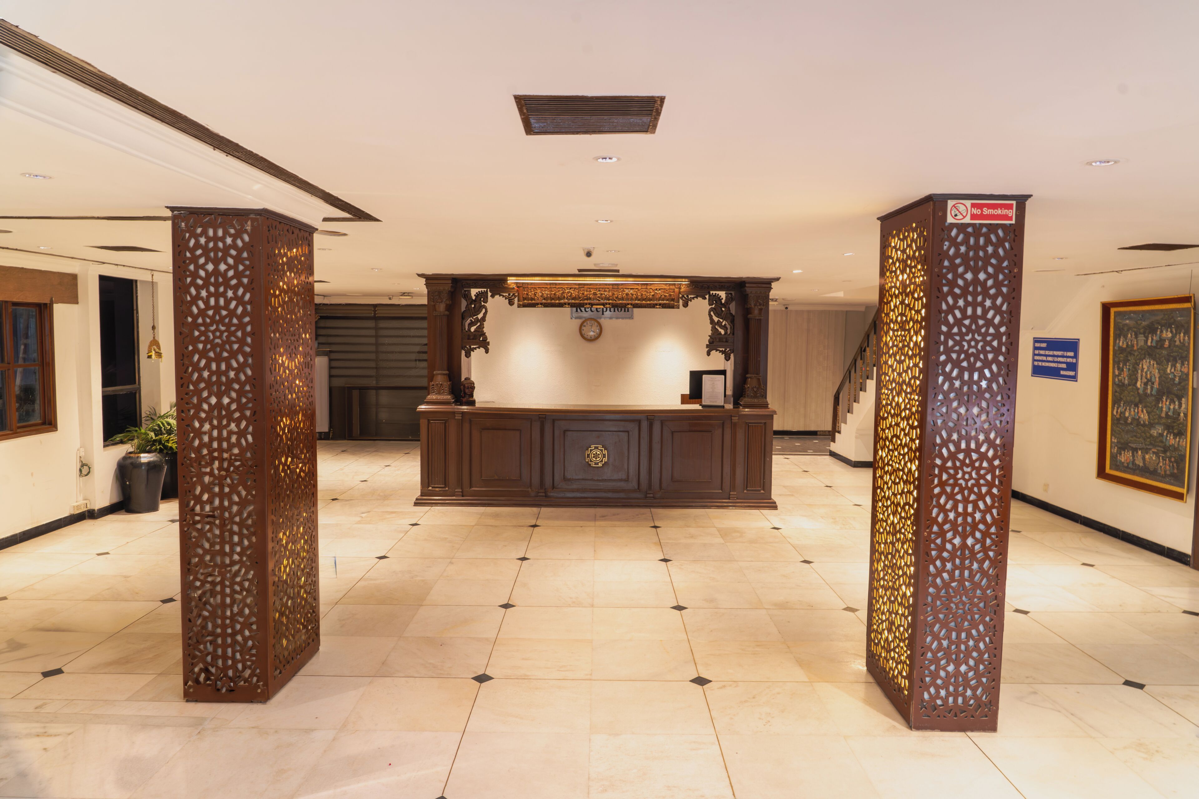 A reception area with a reception desk, a clock, and a 'No Smoking' sign.
