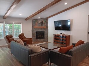 Una sala de estar con chimenea, televisor y sofá.