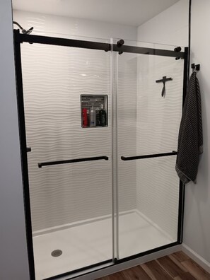 Een douche, een bubbelbad, handdoeken, zeep