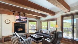 Una sala de estar con chimenea, un sofá, un sillón reclinable y un televisor.