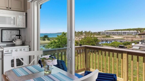 Ein Balkon mit Blick auf das Meer und ein Gebäude gegenüber.