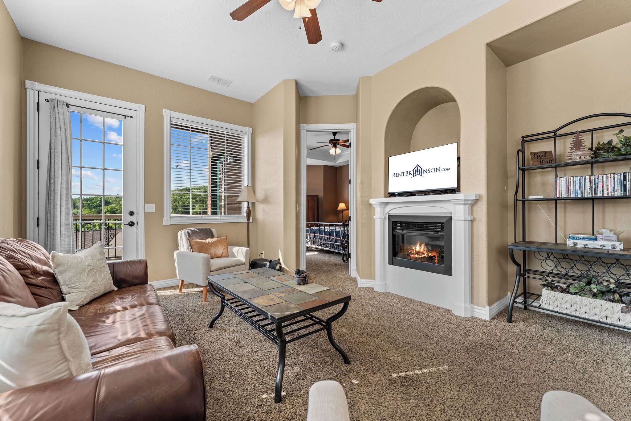 A living room with a fireplace, a sofa, a coffee table, and a bookshelf.