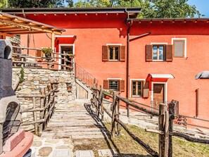 A stone staircase leading to a red building with wooden railings and shutters. - Apartment Olivo by Interhome (Sorico Albonico)