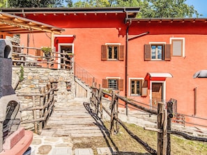 A stone staircase leading to a red building with wooden railings and shutters. - La Palma by Interhome (Sorico Albonico)