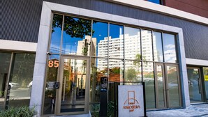 Moderni rakennus, jossa on suuret lasi-ikkunat, kyltti, jossa lukee ”CIVIVA ATMOSFERA 360º”, ja oven päällä numero ”85”.
