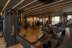 Ein Fitnessstudio mit Laufbändern, Kraftgeräten und Spiegeln.
