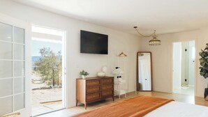 A bedroom with a bed, a dresser, a mirror, and a TV. - Sunflower - 40 Acres, Pool, Pickleball, Game Room! (Joshua Tree)