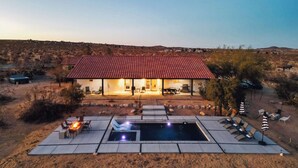 A house with a red-tiled roof, a swimming pool, and outdoor seating. - Sunflower - 40 Acres, Pool, Pickleball, Game Room! (Joshua Tree)