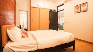 Un dormitorio con cama, armario, puerta y aire acondicionado.