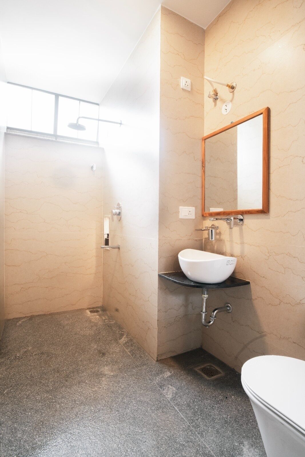 Un baño con ducha, lavabo con espejo e inodoro.