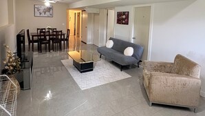 Un grand espace de vie comprenant un canapé, une table basse et un coin repas avec des chaises et une table.