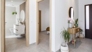 Ein modernes Badezimmer mit einem weißen Waschbecken, Spiegel und WC.