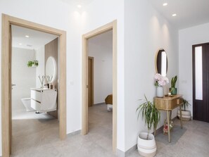 Ein modernes Badezimmer mit einem weißen Waschbecken, Spiegel und WC.