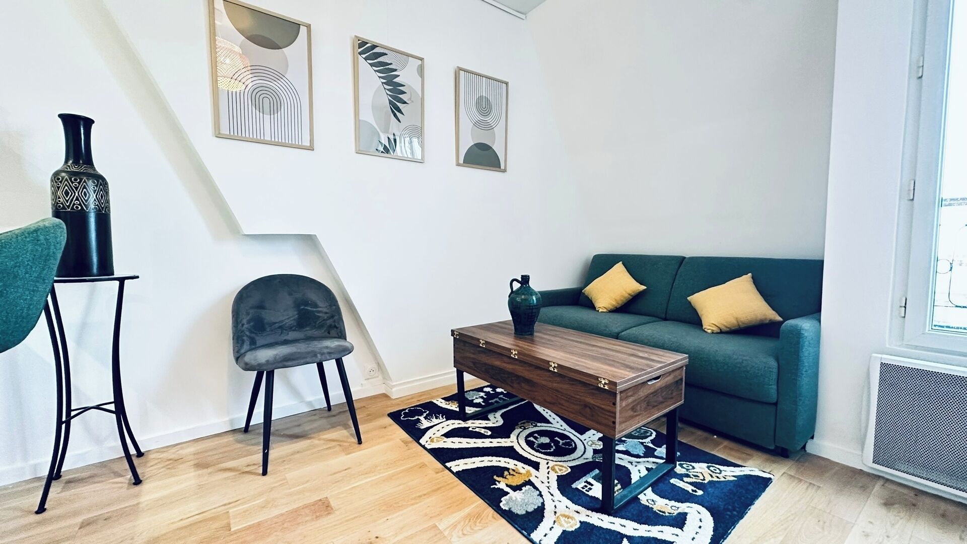 Una sala de estar moderna con un sofá verde, una mesa de centro de madera, una silla negra y una alfombra decorativa.