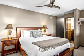 A bedroom with a bed, two bedside tables, a ceiling fan, and a door leading to a bathroom. - Cozy Mountain Loft Ski-in/out+Hot Tub Sleeps 6 (Golden)