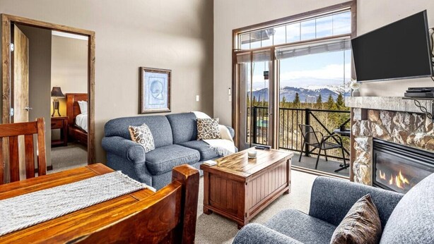 A living room with a sofa, coffee table, and fireplace.