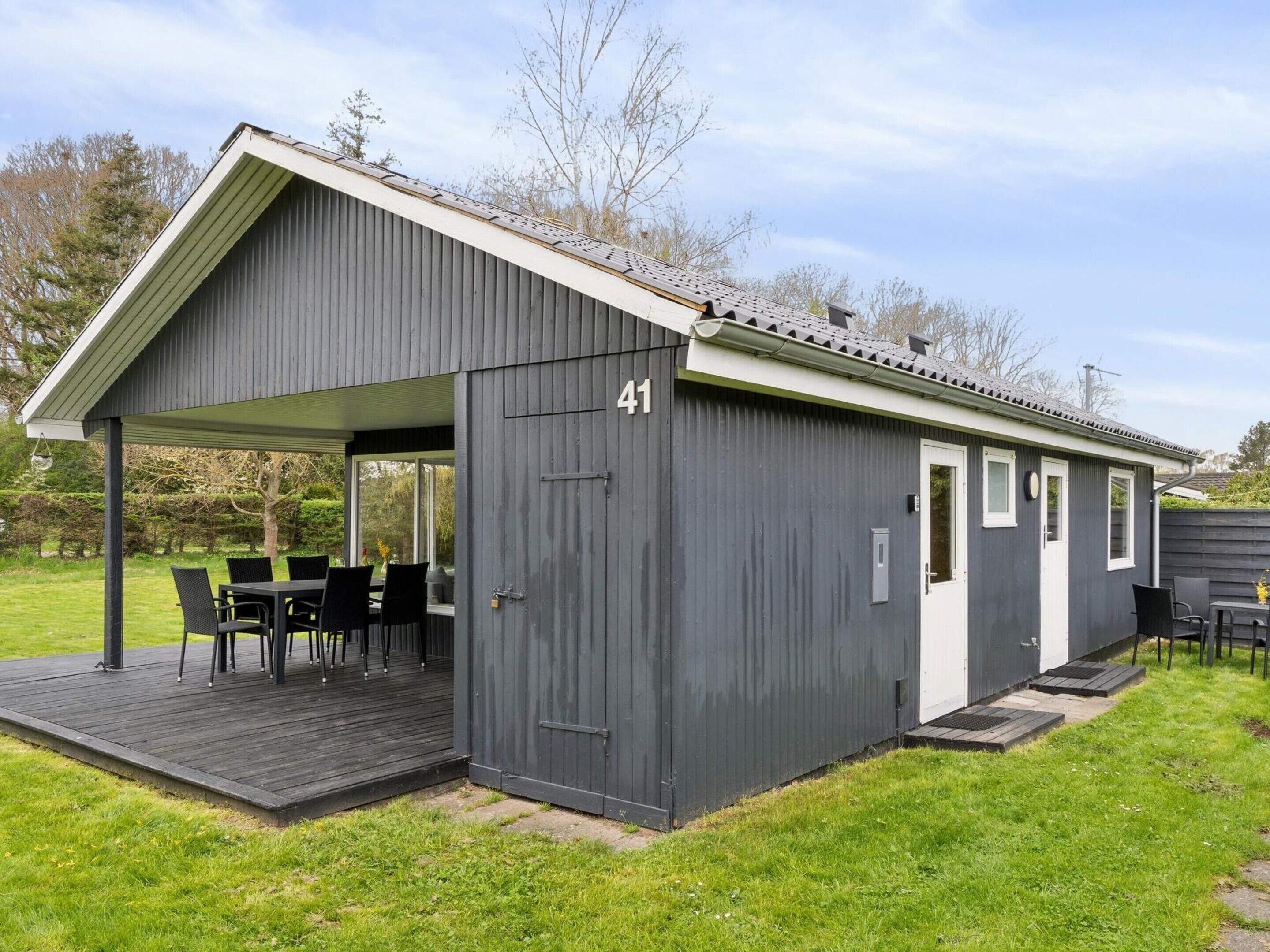 Un bâtiment en métal gris doté d’un patio couvert, portant le numéro 41, et auquel est adjointe une petite construction.