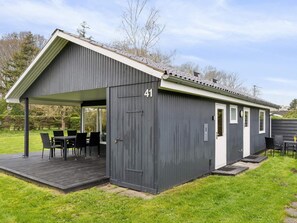 A grey metal building with a covered patio, numbered 41, and a small attached structure. - 5 Star Holiday Home in Odder (Odder)