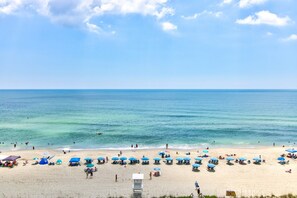 A beach with umbrellas and people. - Oceanfront 1 Bedroom Condo in Carolina Beach 0808 (Carolina Beach)