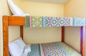 Ein Etagenbett mit gemustertem Bettbezug und einem Kissen auf der unteren Liege.
