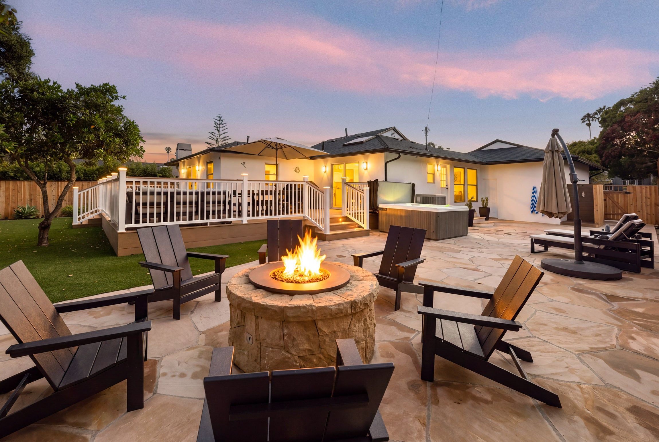 A patio area with a fire pit, outdoor seating, and a covered deck.