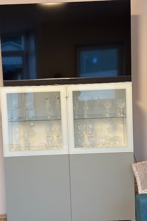 A glass-fronted cabinet with wine glasses inside. - FEWO „Am Stausee“ by Interhome (Friesoythe)