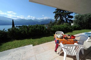 A patio with a table set for dining, overlooking a lake and mountains. - Holiday flat with a view of the Bay of Val di Sogno (Malcesine)
